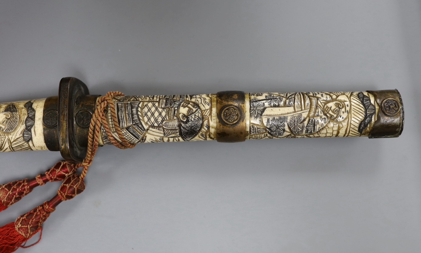 A late 19th century Japanese wakizashi sword, the blade 47.5cm, with sectional stag's horn scabbard and hilt carved with warriors and other figures, gilt metal mounted